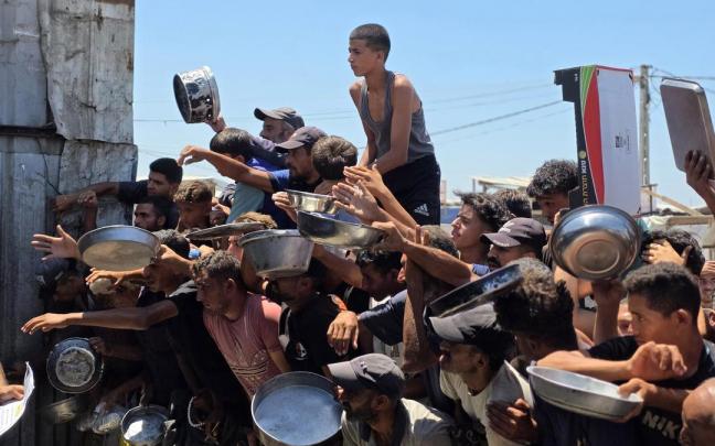 Palestinos se agolpan para conseguir comida.