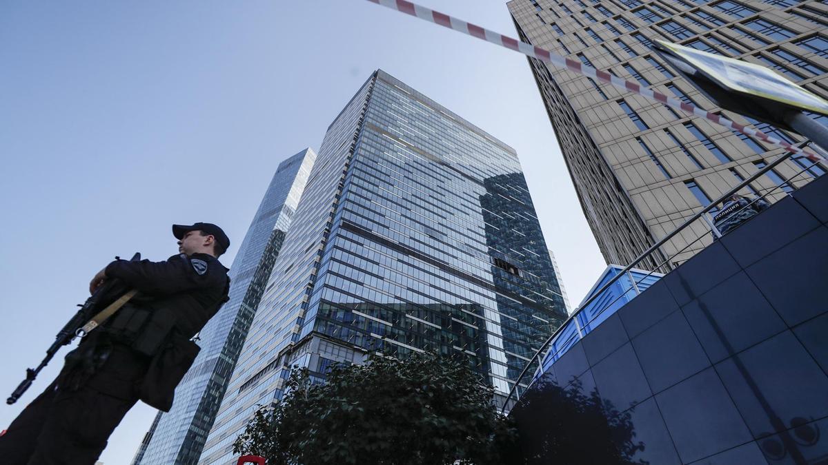 Un agente de la Policía rusa frente al edificio dañado por el ataque ucraniano en Moscú.