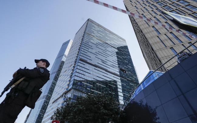 Un agente de la Policía rusa frente al edificio dañado por el ataque ucraniano en Moscú.