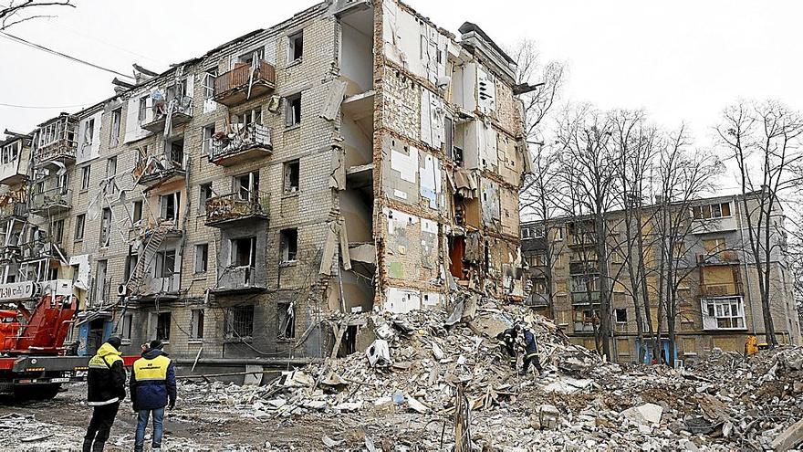 Varias personas observan los destrozos causados por un misil ruso caído el martes sobre un edificio de viviendas en Járkov, que causó la muerte de diez personas.