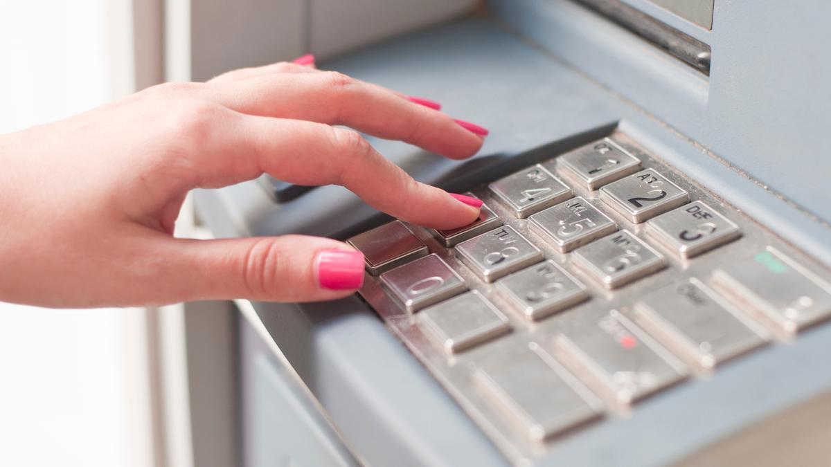 Una mujer realiza una operación bancaria en un cajero.