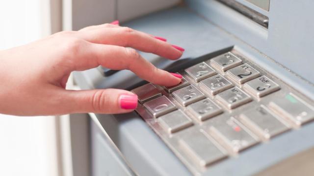 Una mujer realiza una operación bancaria en un cajero.