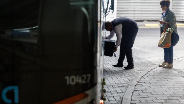 Viajeros depositando sus maletas en el maletero de un autobús.