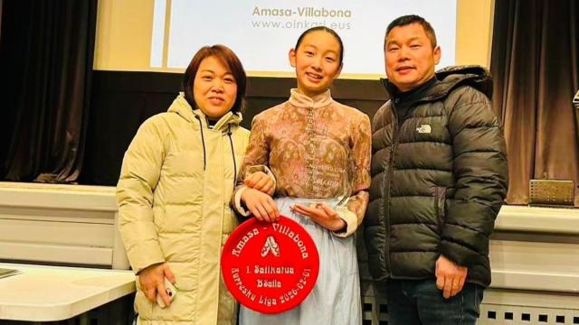 Yisha Wang y sus padres, en Villabona, con la txapela y el trofeo.