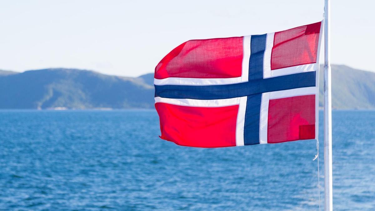 Una bandera de Noruega ondea sobre el mar.