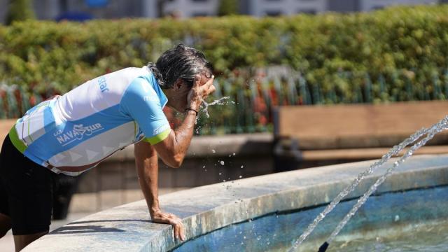 Un ciclista se refresca en una fuente de Oviedo.