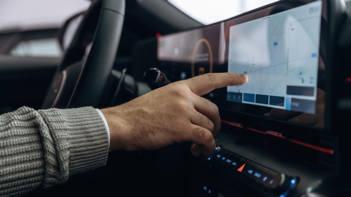 Un hombre maneja la gran pantalla táctil de su coche.
