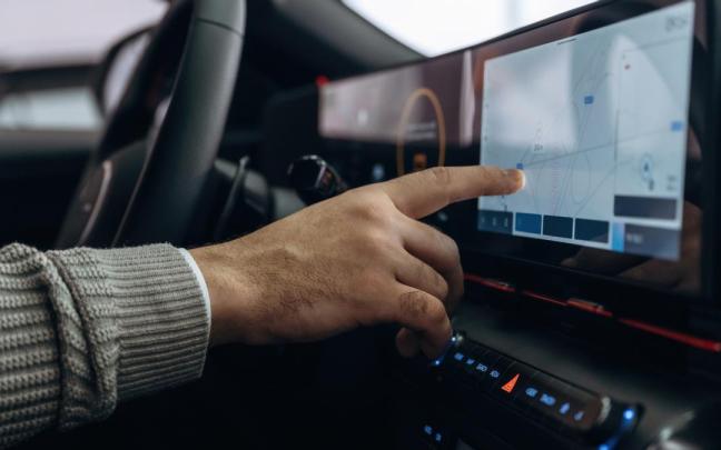 Un hombre maneja la gran pantalla táctil de su coche.