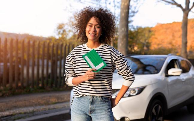 Una joven posa con la placa que acredita que es conductora novel.
