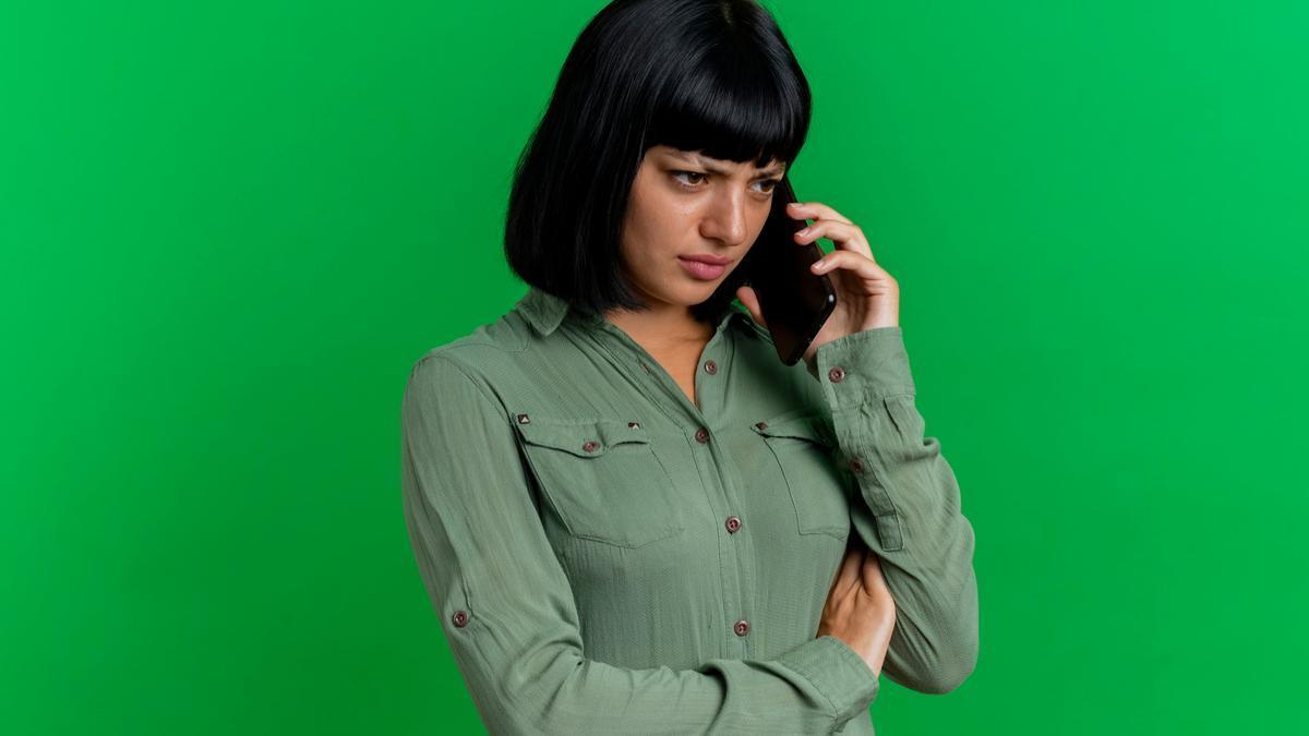 Una mujer atiende una llamada en su teléfono móvil.