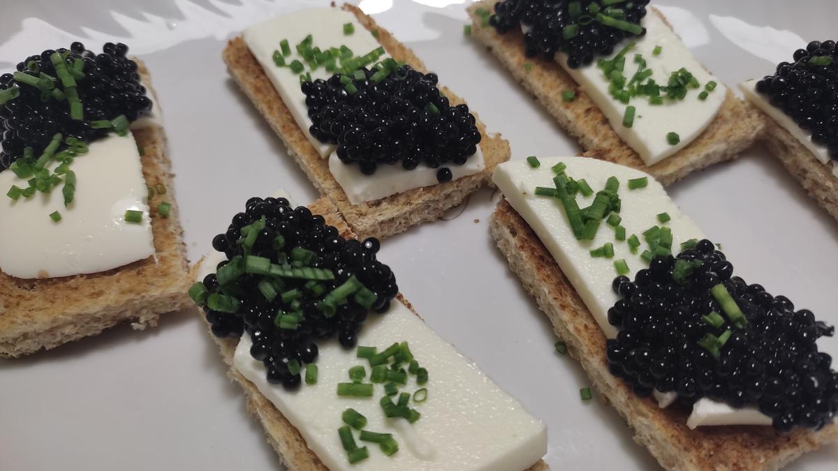 Una sencilla tosta de queso y caviar negro, que puede sustituirse por aceituna negra picada.