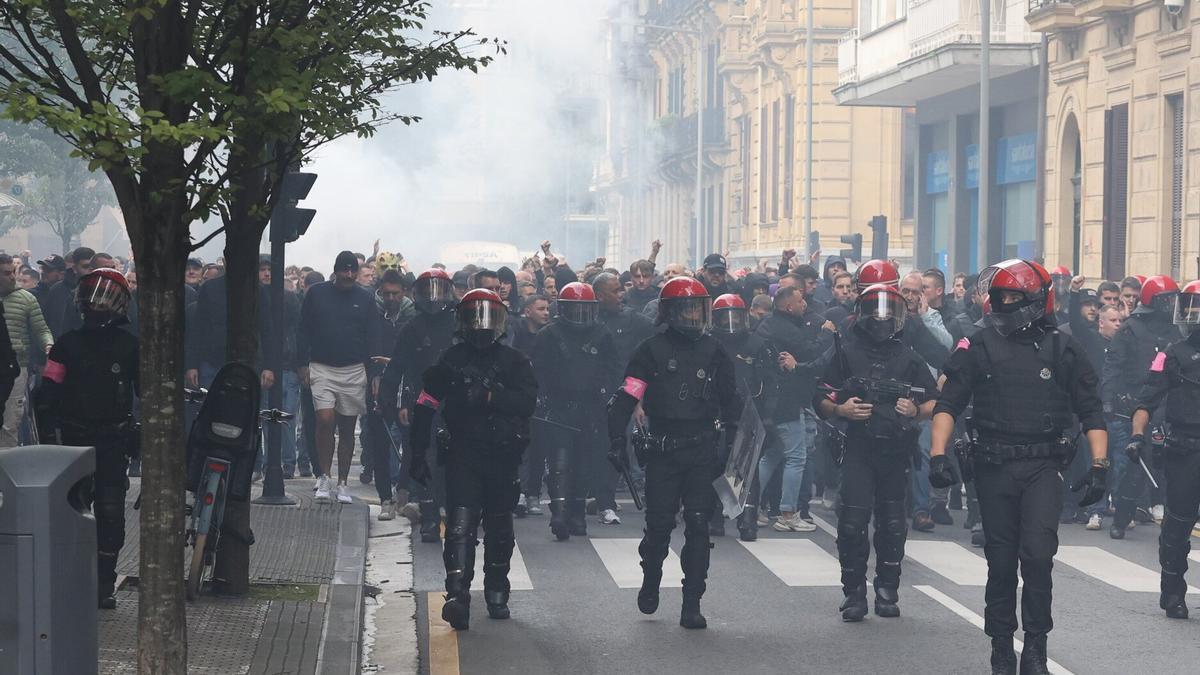 Ultras del Anderlecht, escoltados por la Ertzaintza por la calle Prim de Donostia. / IKER AZURMENDI