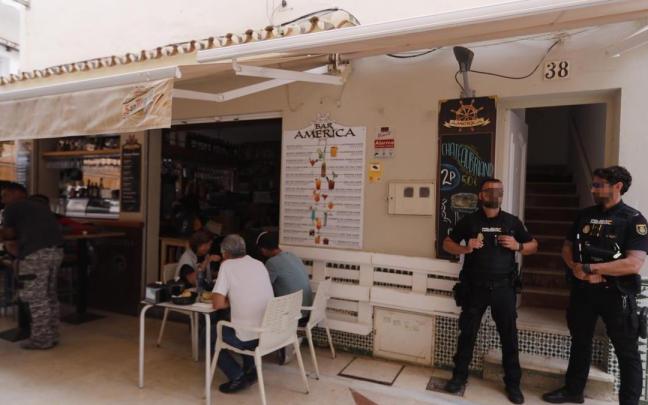 Agentes de la Policía Nacional junto a la entrada de la vivienda número 38 de la calle San Ginés en Torremolinos (Málaga) donde ha sido encontrado el cadáver de una mujer de 28 años.