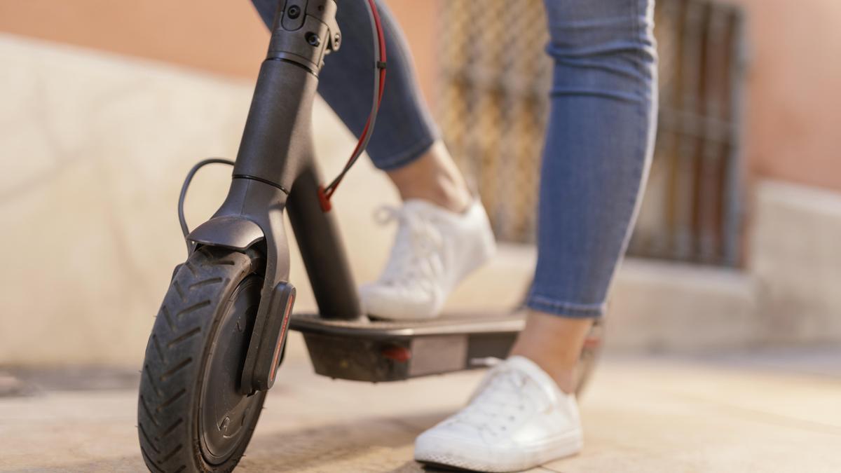 Una mujer, en un patinete eléctrico.