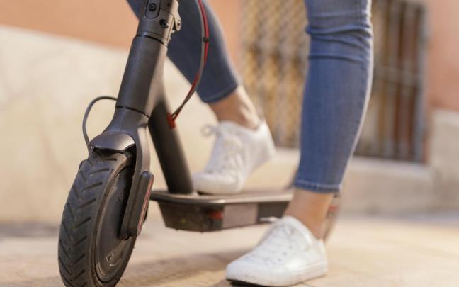 Una mujer, en un patinete eléctrico.