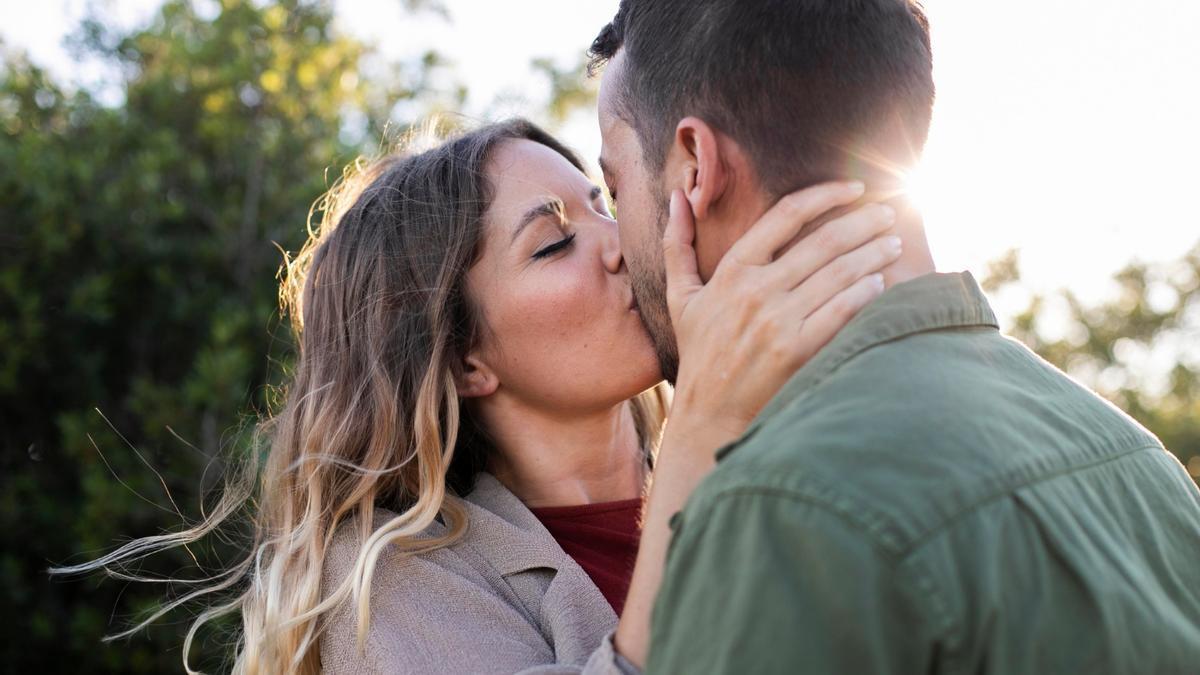 Una pareja, dándose un beso.