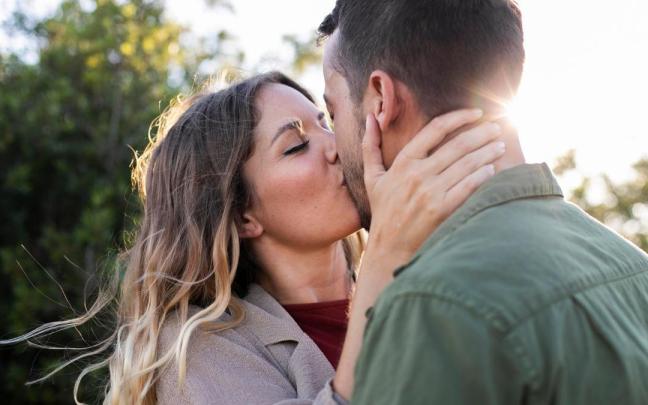 Una pareja, dándose un beso.