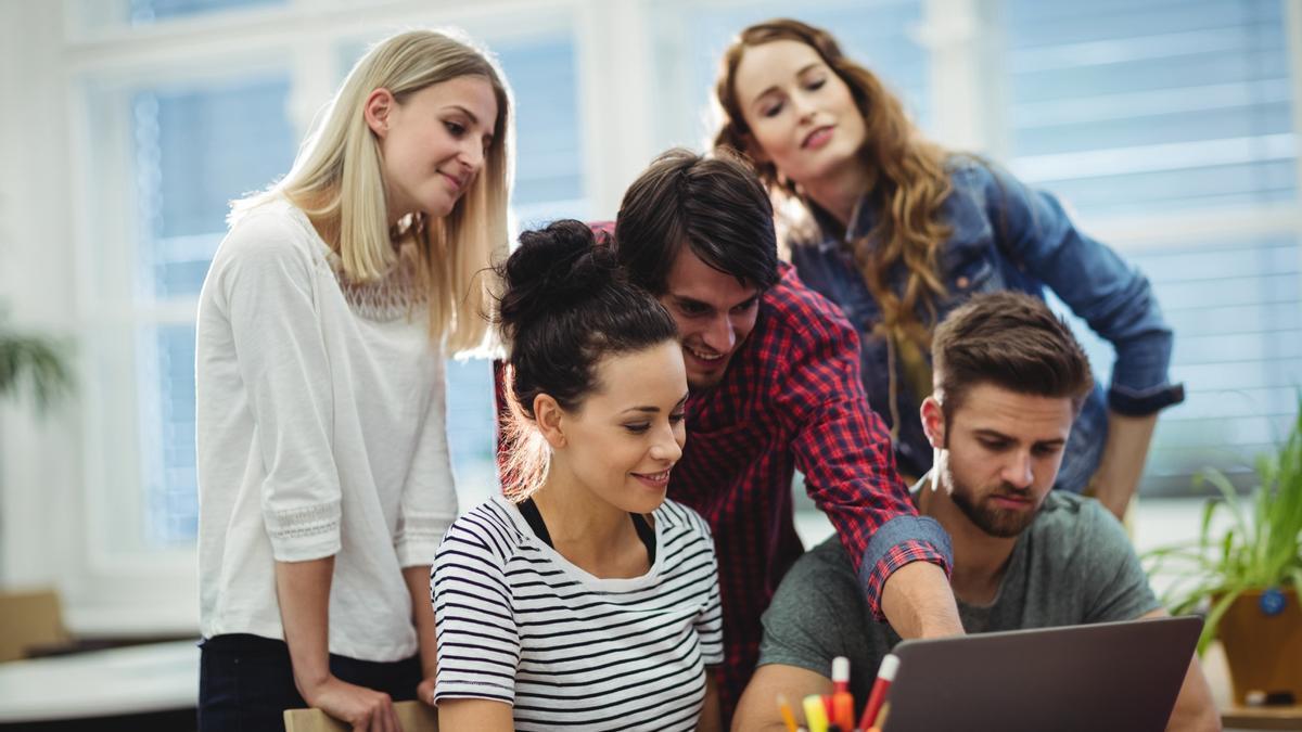 Jóvenes trabajan en equipo en una empresa.
