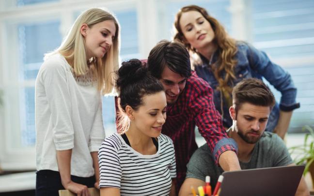 Jóvenes trabajan en equipo en una empresa.