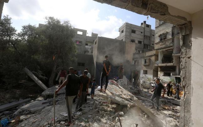 Palestinos observan la devastación causada por ataques israelíes, en una imagen de archivo.