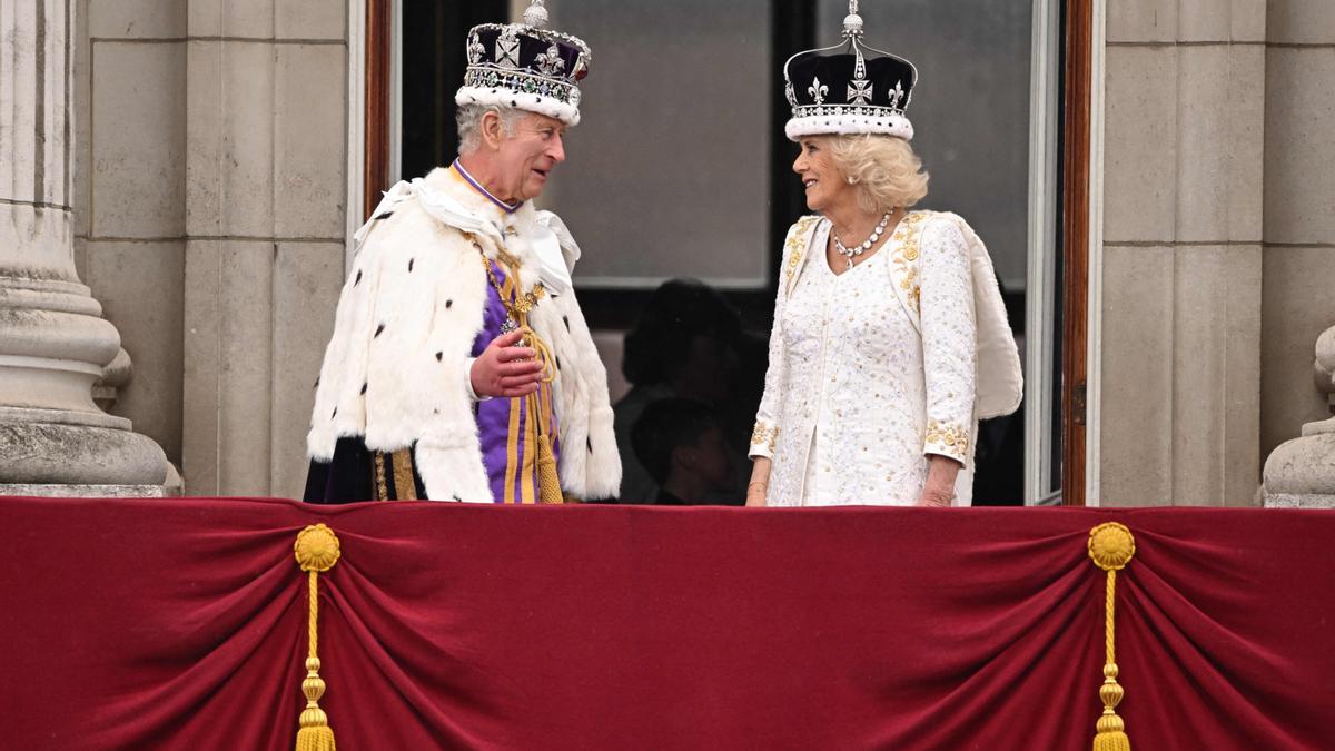 Carlos III y Camila se miran sonrientes en el balcón tras ser coronados.