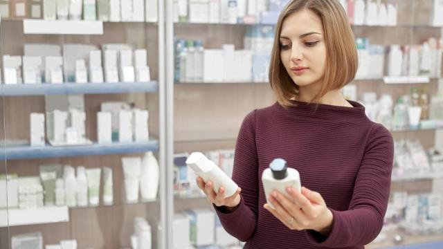 Una mujer revisa los componentes de dos champús.