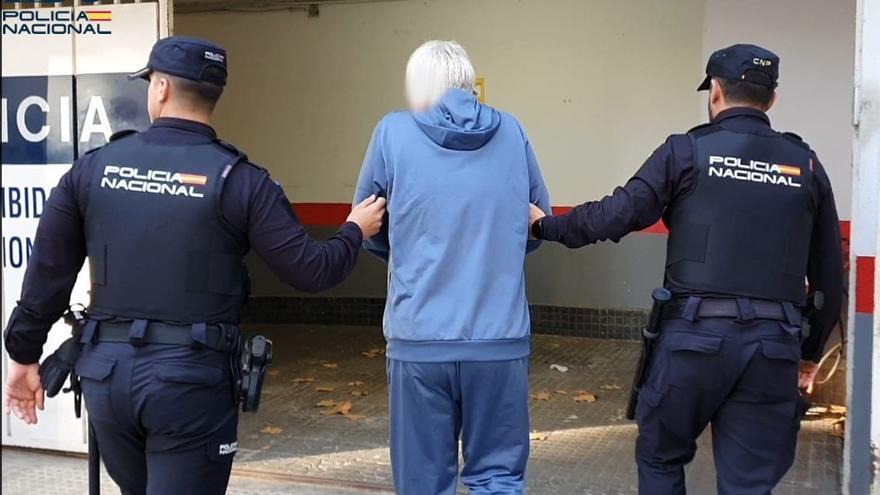 Dos policías nacionales se llevan a una persona arrestada