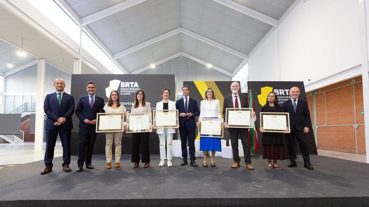 Representantes institucionales, con el lehendakari a la cabeza, de BRTA, y las personas premiadas por su labor investigadora en el acto celebrado en Barakaldo.