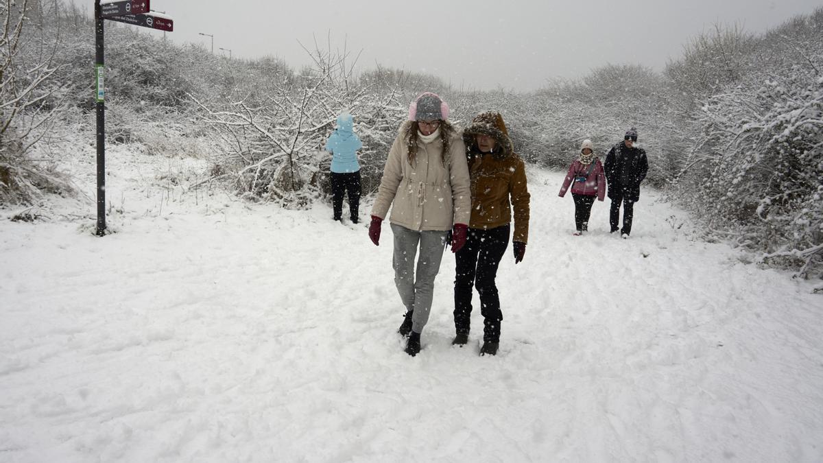 Varias personas disfrutan de la nieve en la calle de Gasteiz
