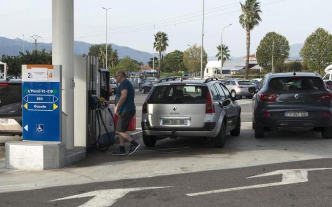 Un hombre repostando gasolina en una estación de servicio.