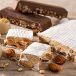 Turrones y figuritas de mazapán sobre una superficie de madera.