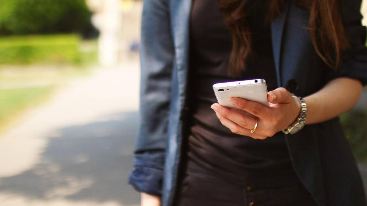 Una mujer sostiene un móvil en una imagen de archivo.