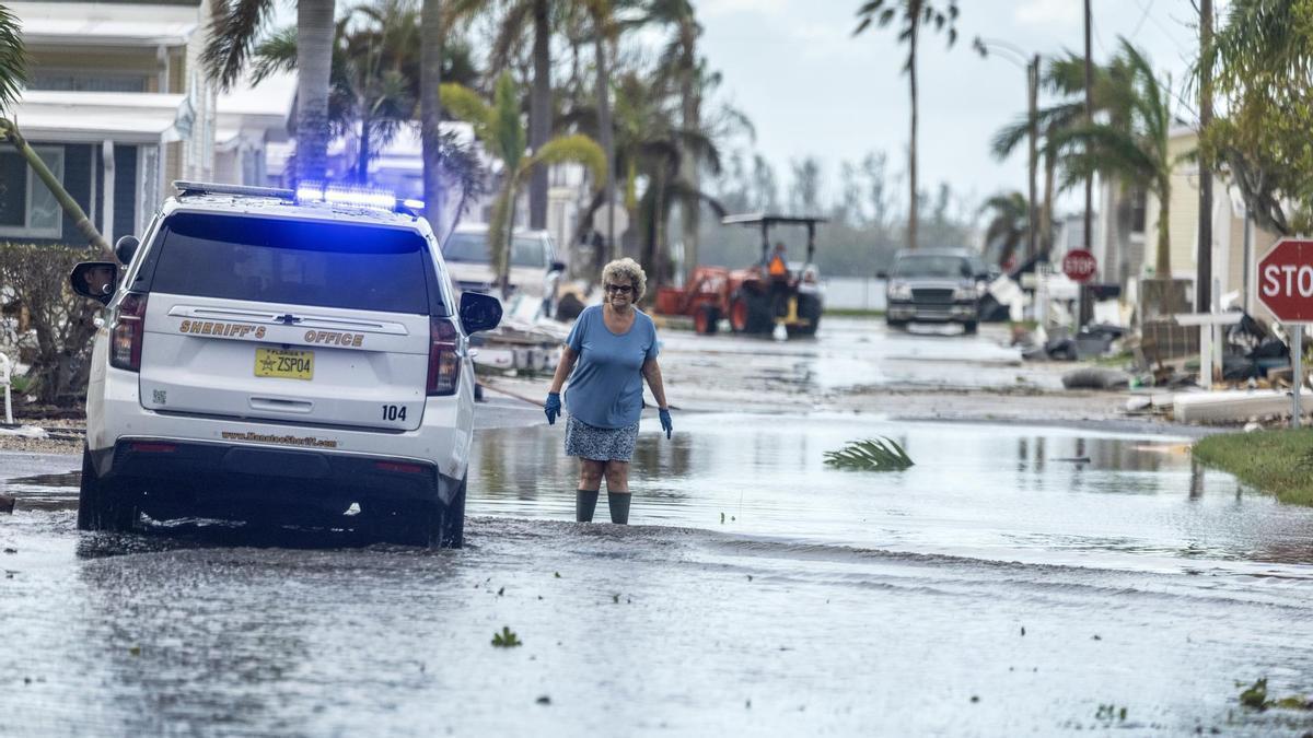 Una mujer camina por una calle inundada tras el paso de Milton en Bradenton, Florida.