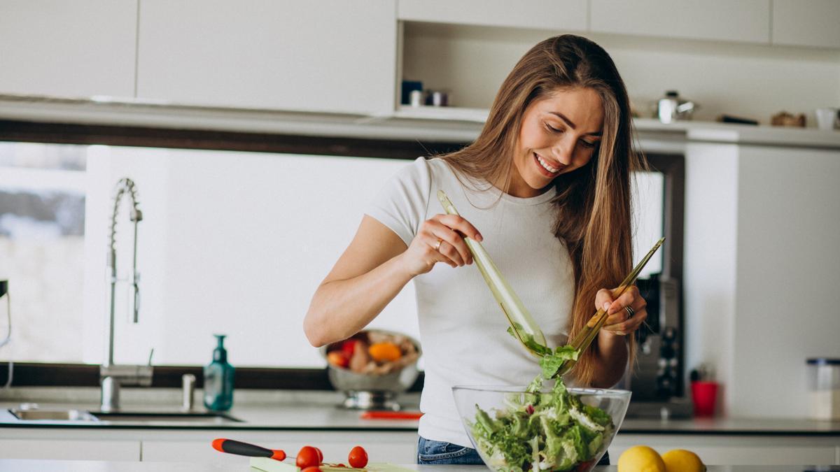 Una mujer prepara una ensalada.