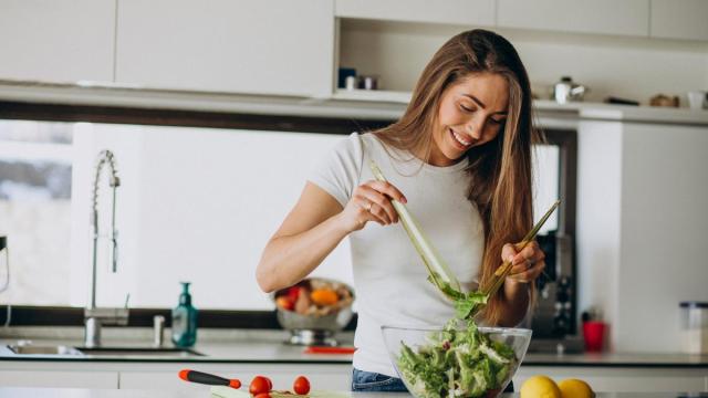 Una mujer prepara una ensalada.