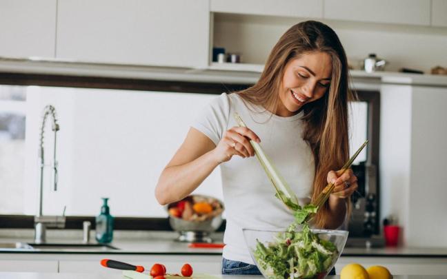 Una mujer prepara una ensalada.