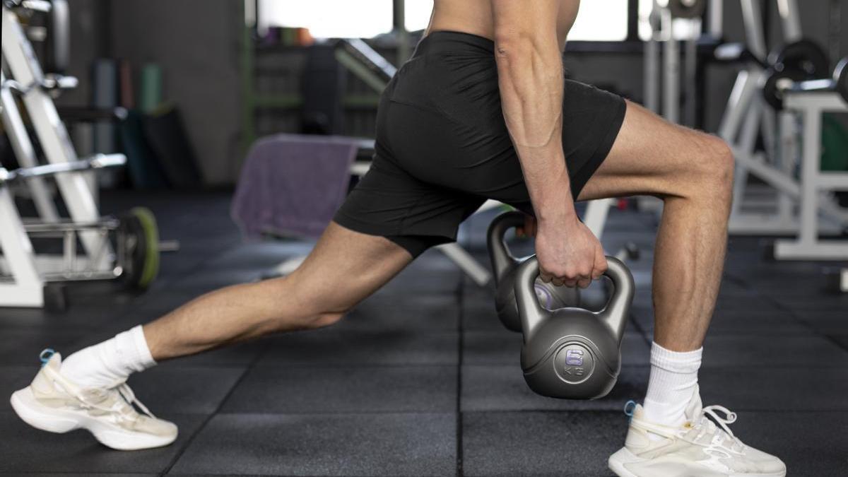 Hombre realiza zancadas con kettlebell