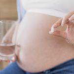 Mujer embarazada sostiene una pastilla | Freepik