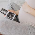 Una mujer embarazada sostiene una ecografía. FREEPIK