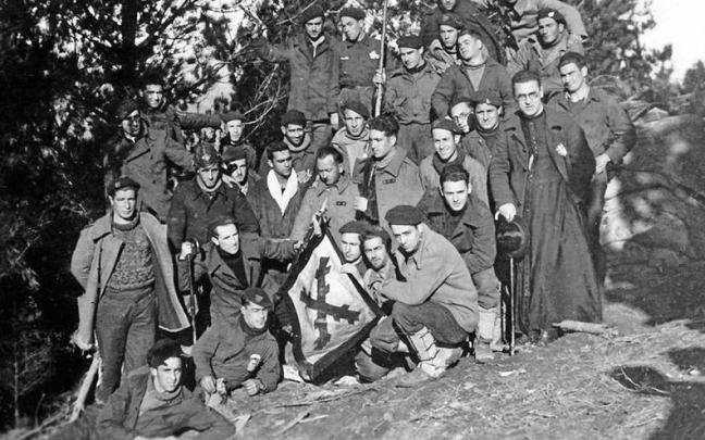Un grupo de mendigoixales muestra una bandera de Euzko Mendigoixale Batza.
