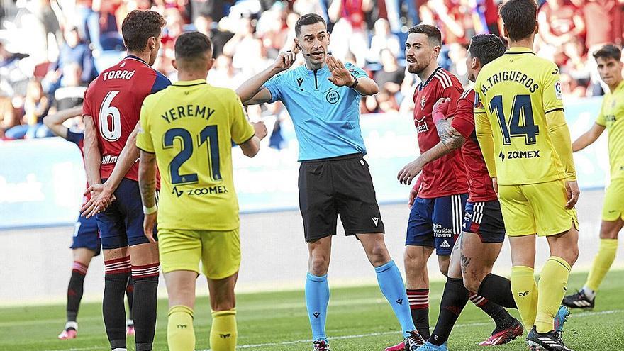 Conversación del árbitro Muñiz Ruiz con el responsable del VAR, Medié Jiménez, presionado por los jugadores de Osasuna, que piden penalti por mano de Yeremy Pino.