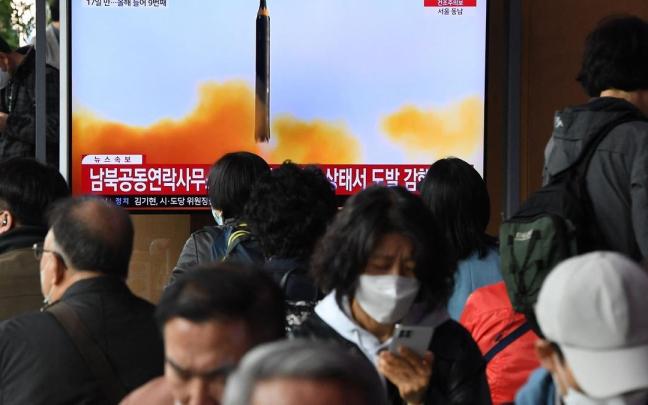Un grupo de civiles observa en televisión el lanzamiento del misil de Corea del Norte.
