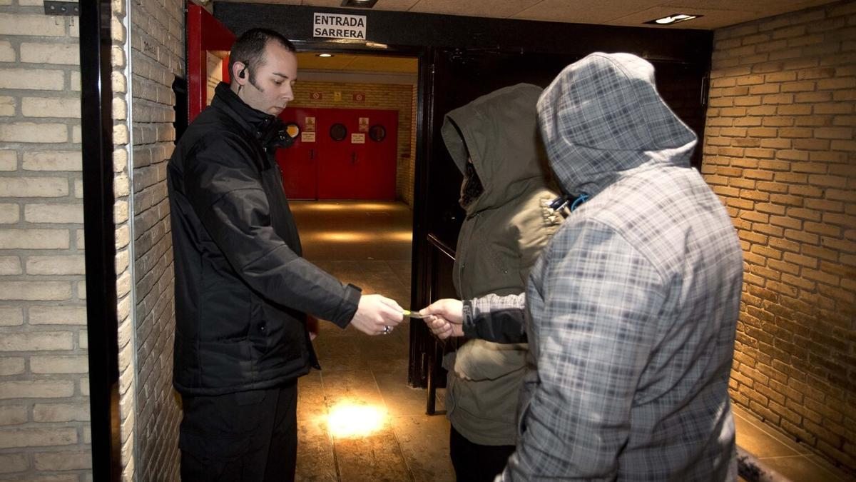 Un portero controla el acceso de unos clientes a una sala de fiestas de la Comarca de Pamplona. Foto: Unai Beroiz