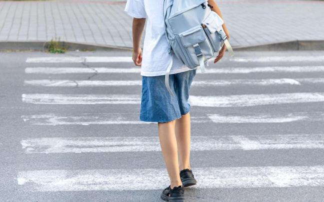 Una menor camina hacia el colegio.