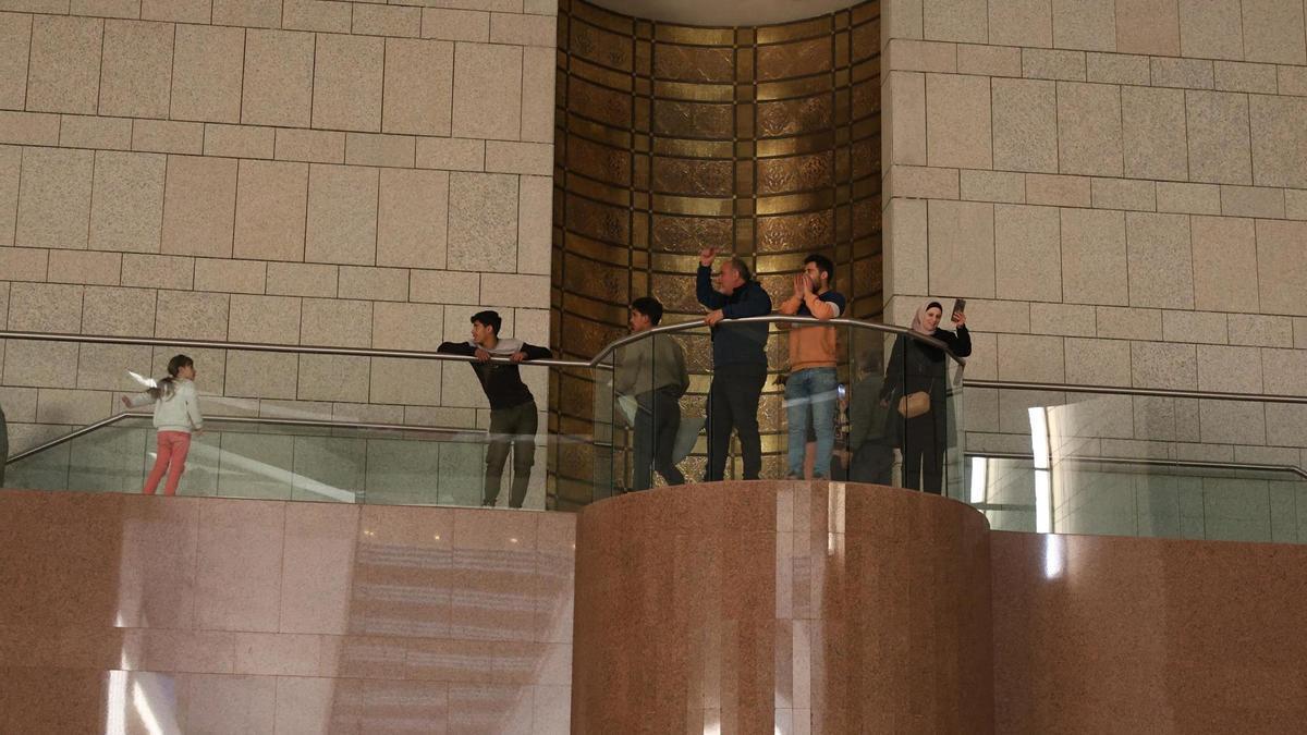 Varias personas asaltan el palacio presidencial sirio, en Damasco, tras la caída del régimen de Al Asad.