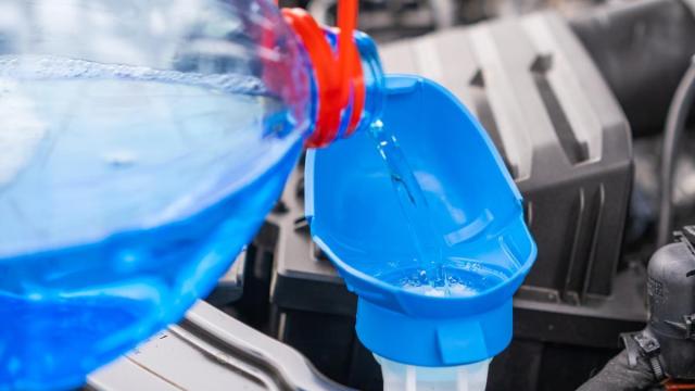 Una persona vierte líquido limpiaparabrisas.