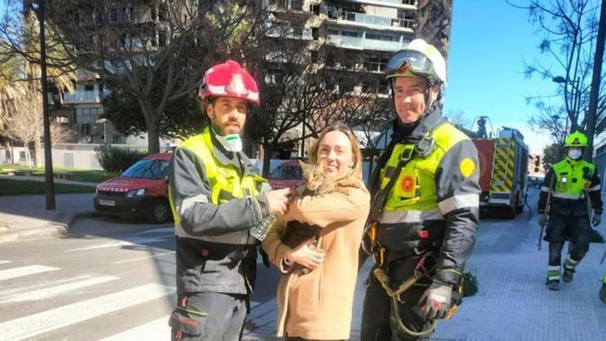 Los bomberos entregan el gato rescatado en Valencia a su dueña.