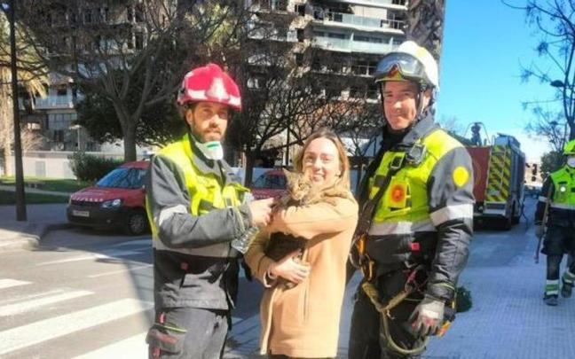 Los bomberos entregan el gato rescatado en Valencia a su dueña.
