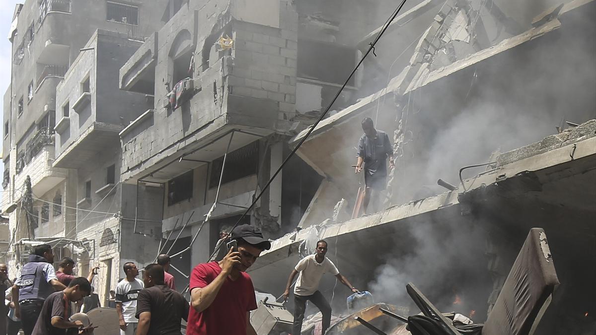 Varios palestinos comprueban los daños causados por un ataque del Ejército de Israel en la ciudad de Gaza.