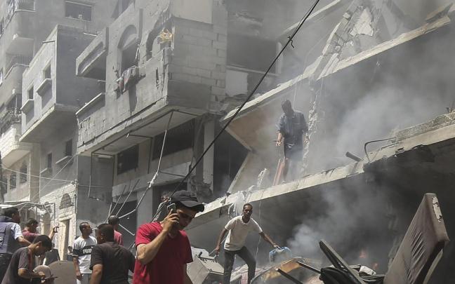 Varios palestinos comprueban los daños causados por un ataque del Ejército de Israel en la ciudad de Gaza.